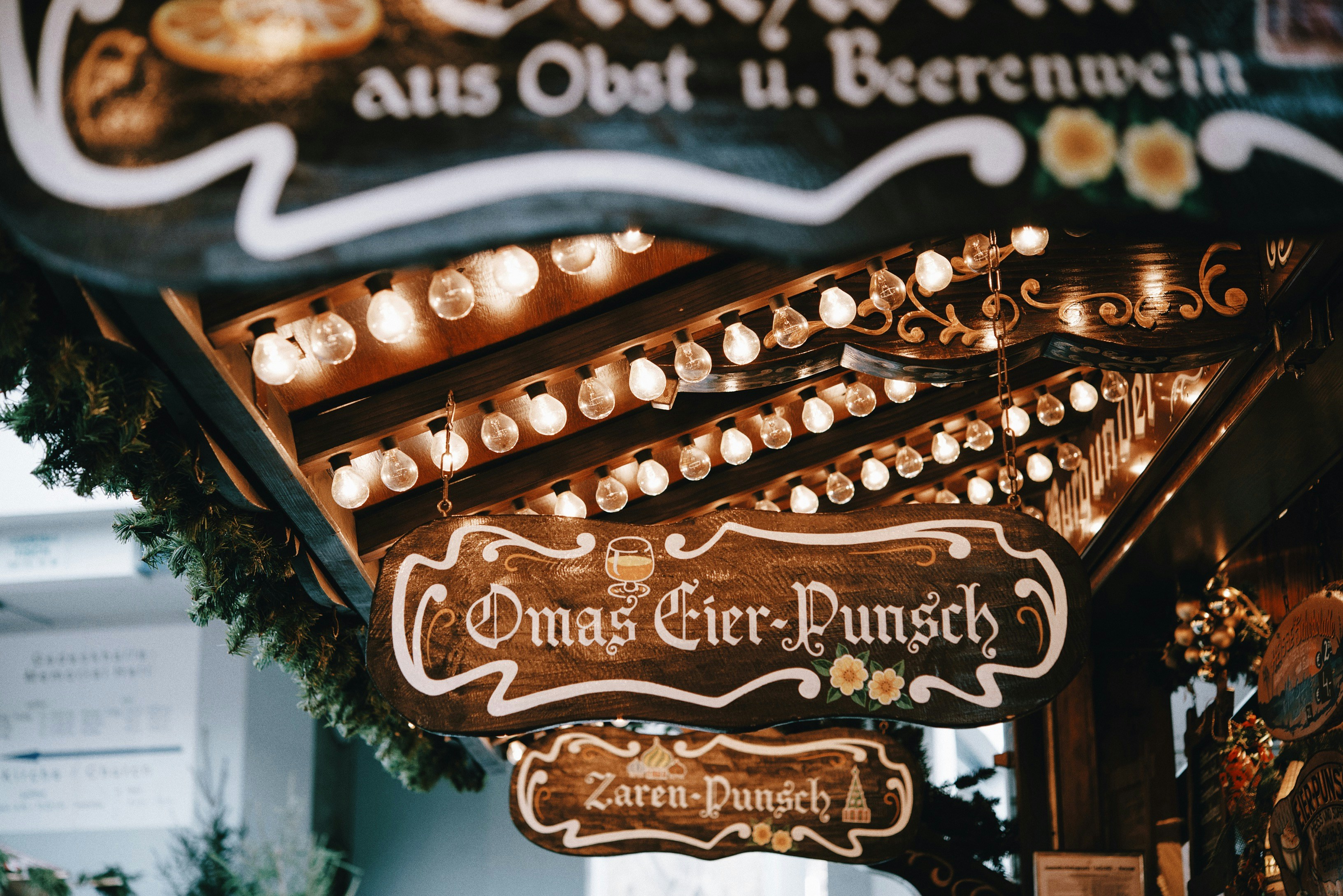 Beleuchtetes Schild eines Eier-Punsch-Standes auf einem Weihnachtsmarkt.