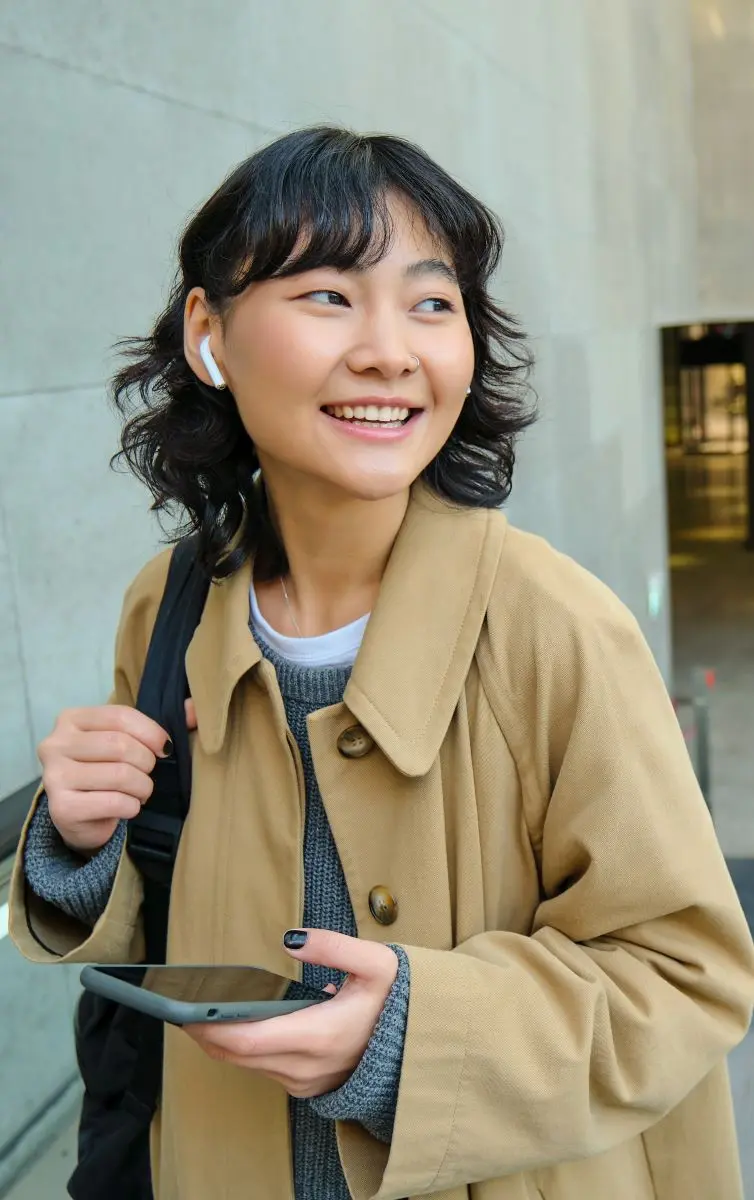 Lachende Frau Mit Handy Und Kopfhoerern Unterwegs Neu