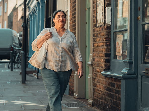 Adult walking briskly through London on a weekday morning.