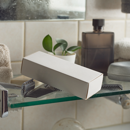 Plain unbranded test kit box on a bathroom shelf with a razor and comb.