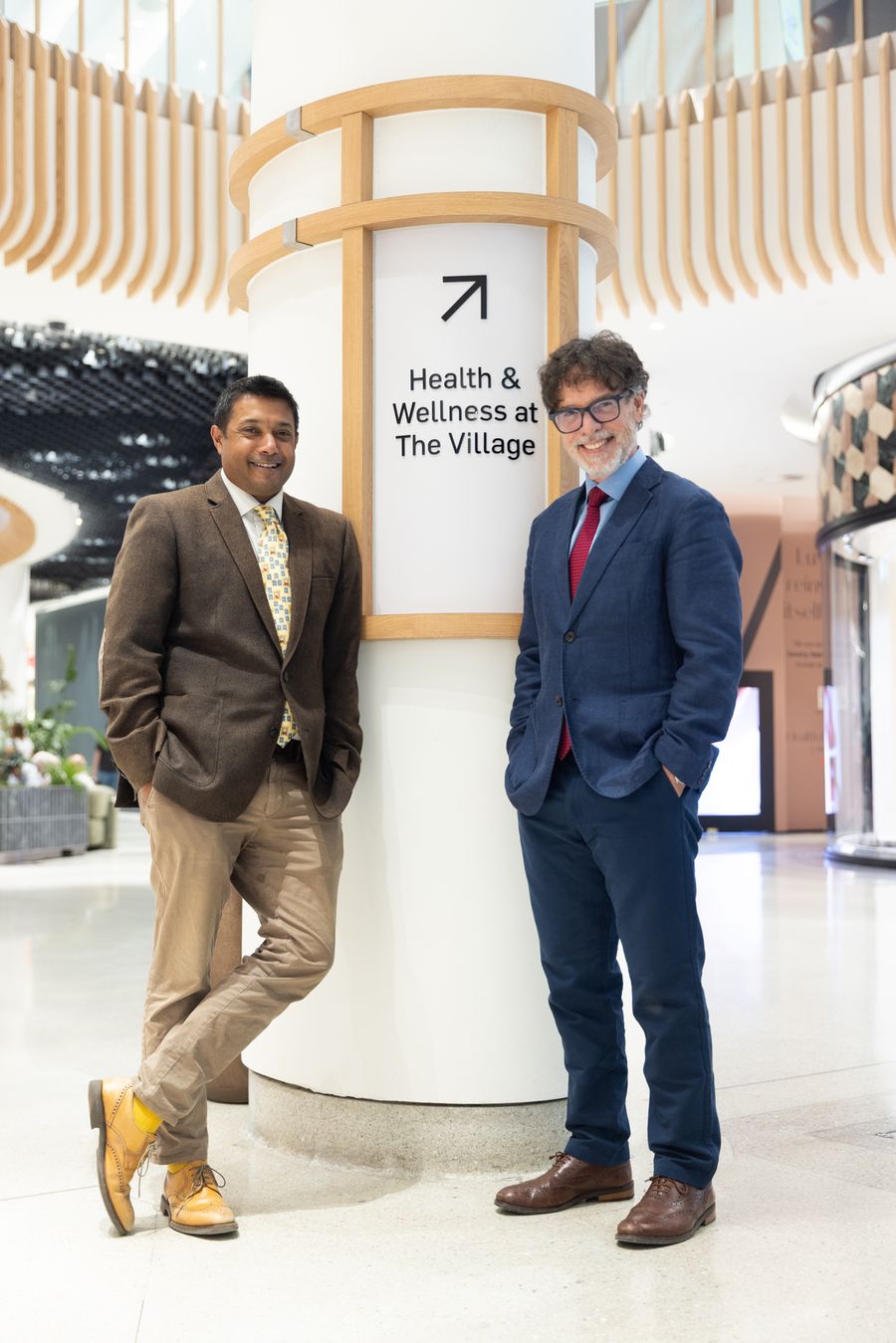 Dr Seth Rankin with a fellow GP by the Health and Wellness at The Village sign, Westfield London