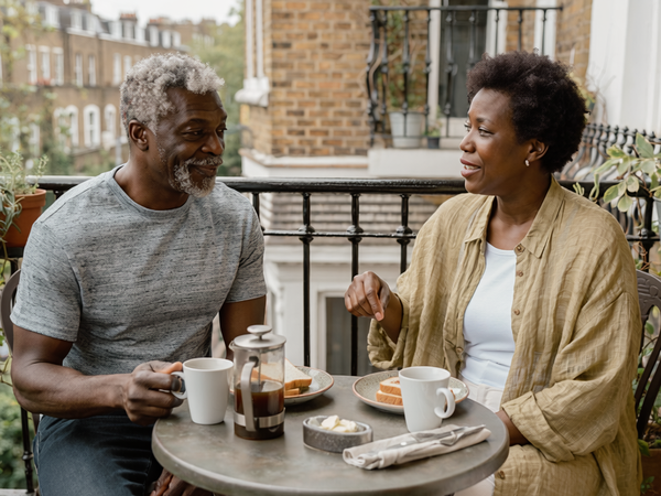 Couple in their fifties having breakfast together on a London balcony.