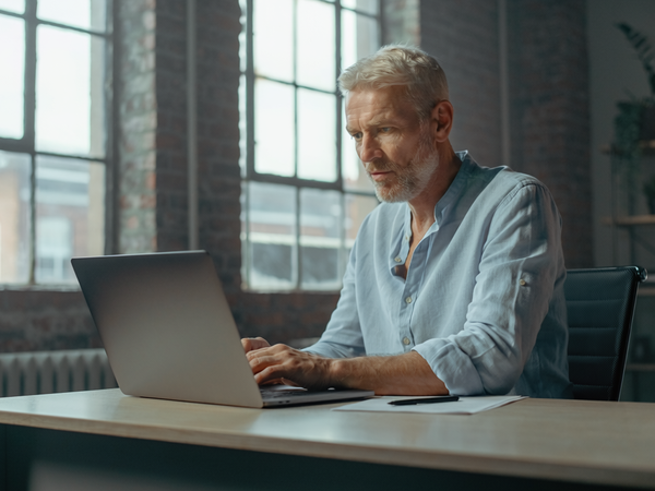 Man in his fifties at a desk in a converted East London warehouse office.