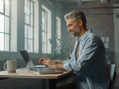 Man in his fifties at a desk in a converted East London warehouse office.