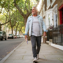 Man walking along a leafy London street.