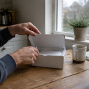 A plain test kit box on a kitchen table by a window.