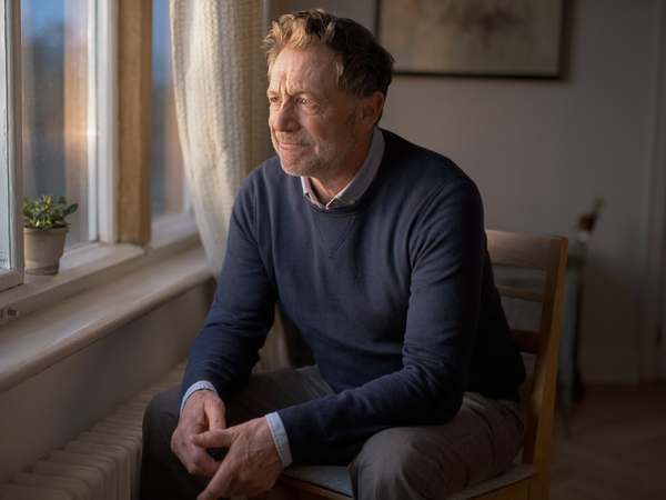 A man in his fifties, reflective.