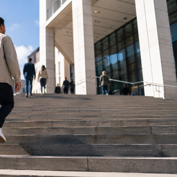 A person climbing the steps of a public health building.