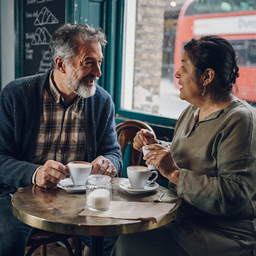 Mixed-heritage couple at a small London cafe by a window.