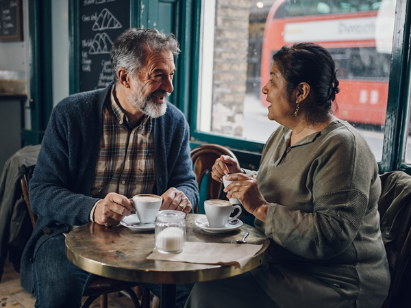 Mixed-heritage couple at a small London cafe by a window.