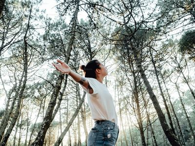 A woman standing among trees