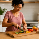 Woman preparing a healthy meal in her kitchen with fresh vegetables on the counter.