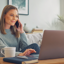 Young adult arranging an appointment by phone and laptop.