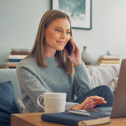 Young adult arranging an appointment by phone and laptop.
