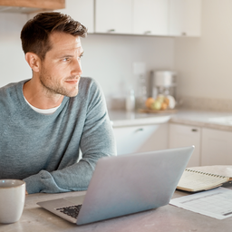 Adult arranging a healthcare appointment on a laptop at home.