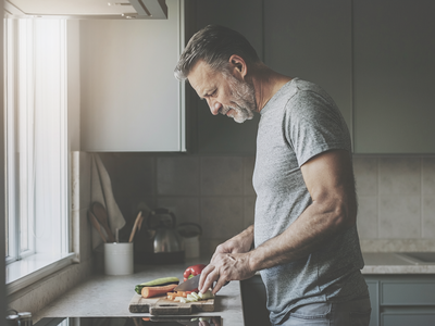 Adult preparing a simple meal in a modern home kitchen.