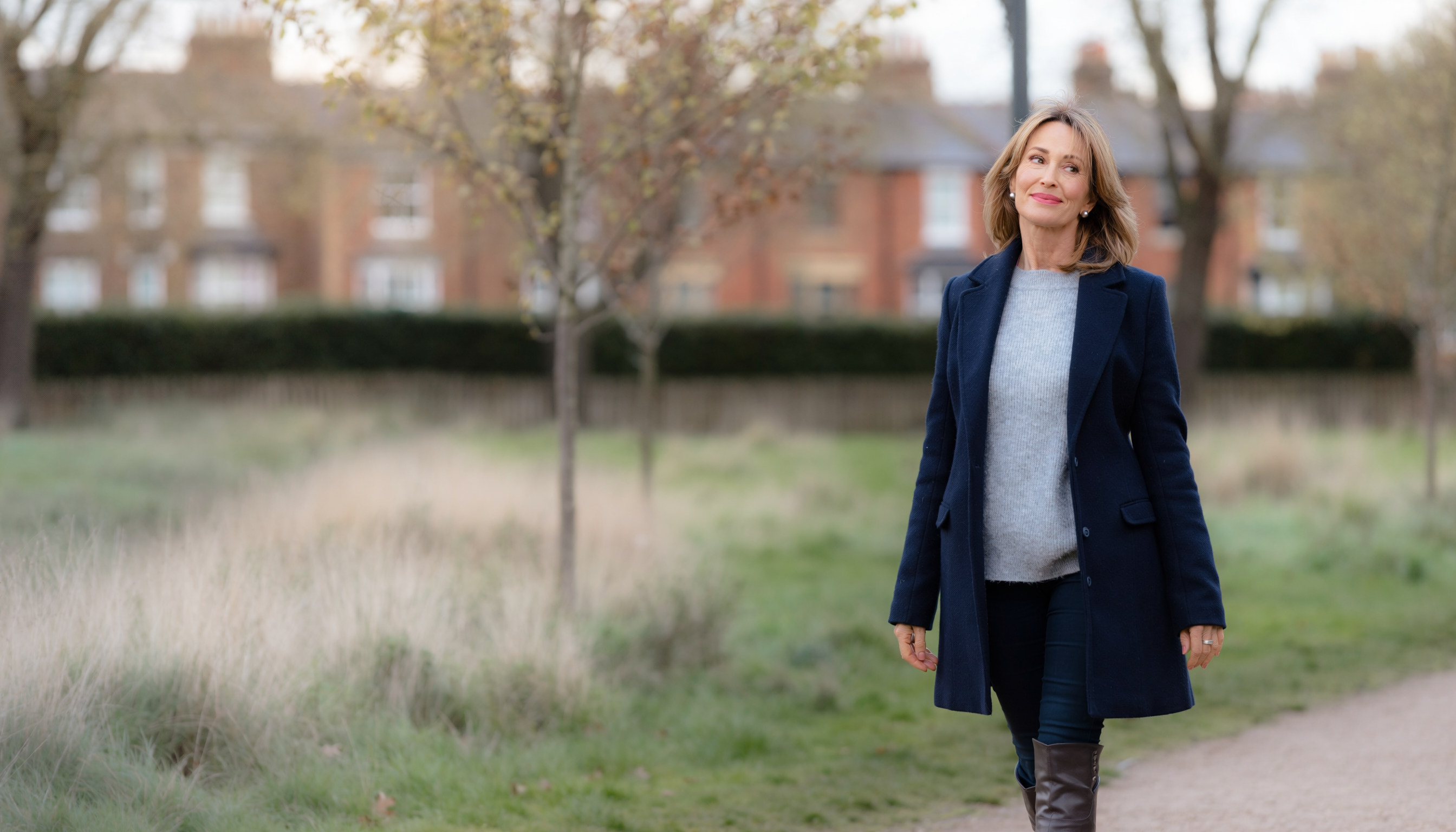 A woman in her 40s walking outdoors looking calm and hopeful, soft daylight