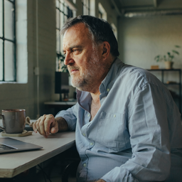 Man in his fifties at a desk in a converted East London warehouse office.