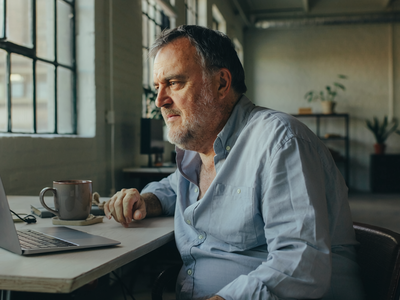 Man in his fifties at a desk in a converted East London warehouse office.