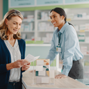 A person reading options at a UK pharmacy counter, everyday high-street setting