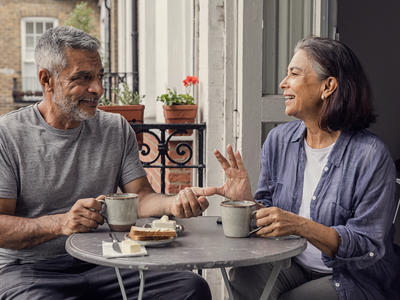 Couple in their fifties having breakfast together on a London balcony.