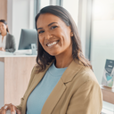 A person smiling confidently after a dental check, bright modern UK dental reception in the background