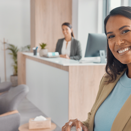 A person smiling confidently after a dental check, bright modern UK dental reception in the background