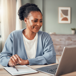 A person comparing healthcare payment options on a laptop at a tidy home desk, considered