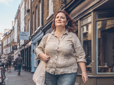 Adult walking briskly through London on a weekday morning.