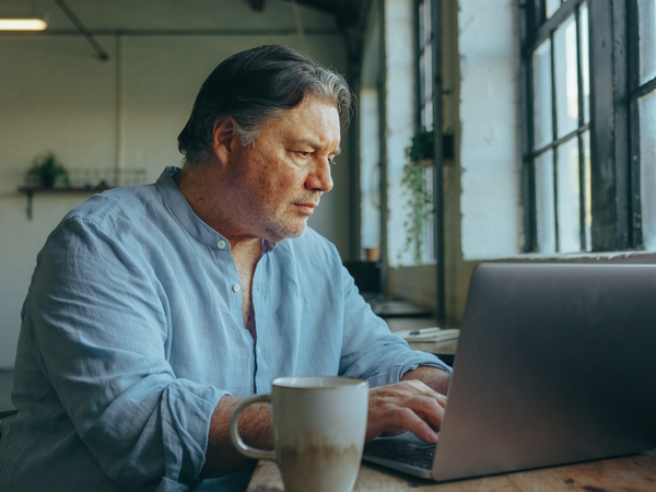 Man in his fifties at a desk in a converted East London warehouse office.