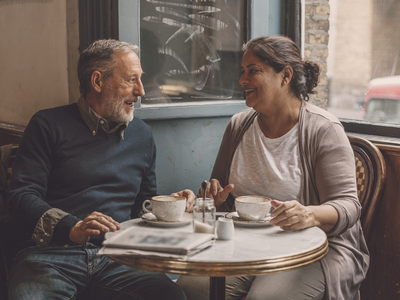 Mixed-heritage couple at a small London cafe by a window.