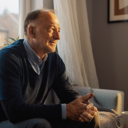 A white British man in his late 40s looking a little tired at the end of the day, sitting by a window, honest and undramatic
