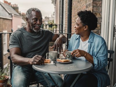 Couple in their fifties having breakfast together on a London balcony.