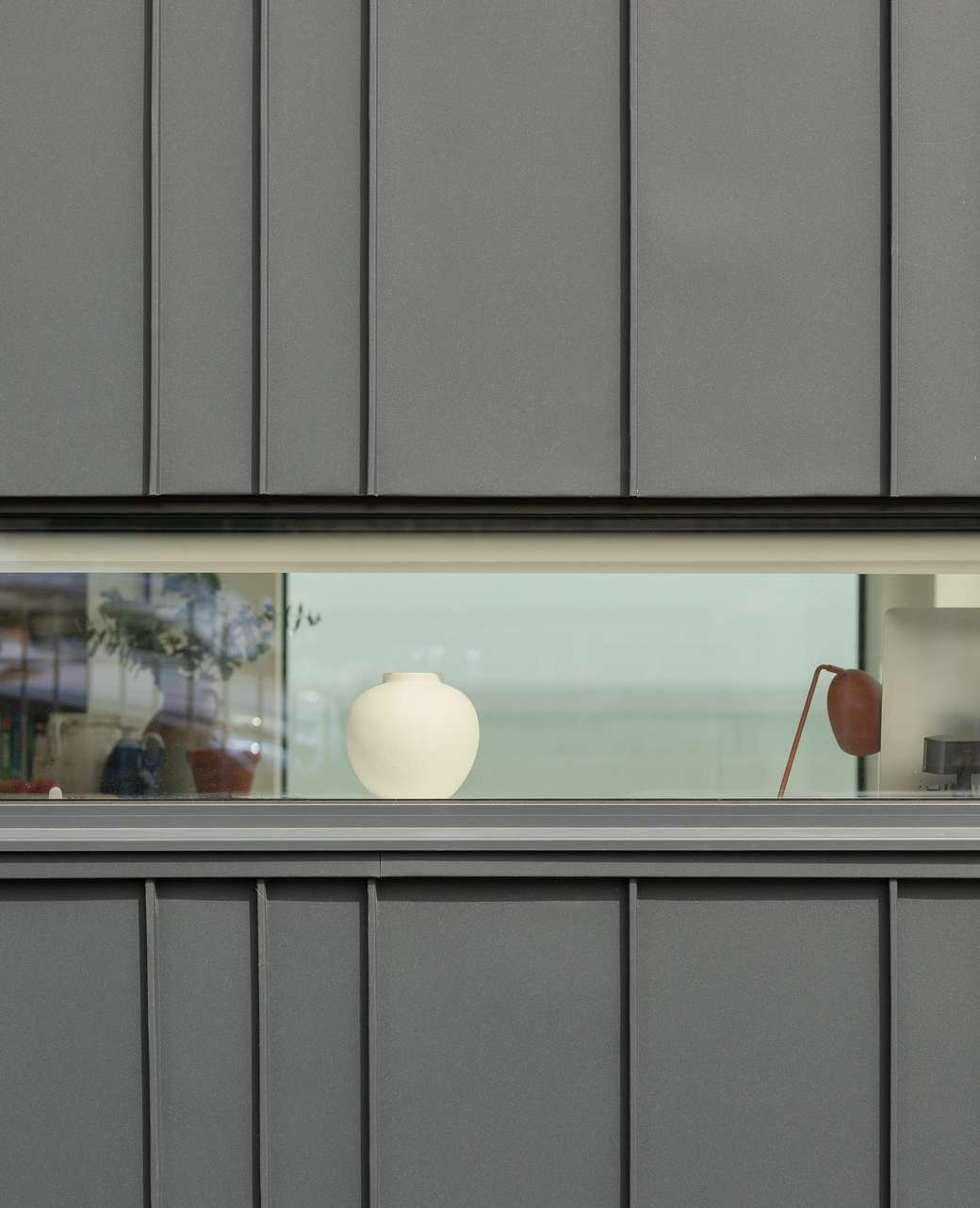 A narrow horizontal Fluid aluminium casement window at Sea Breeze