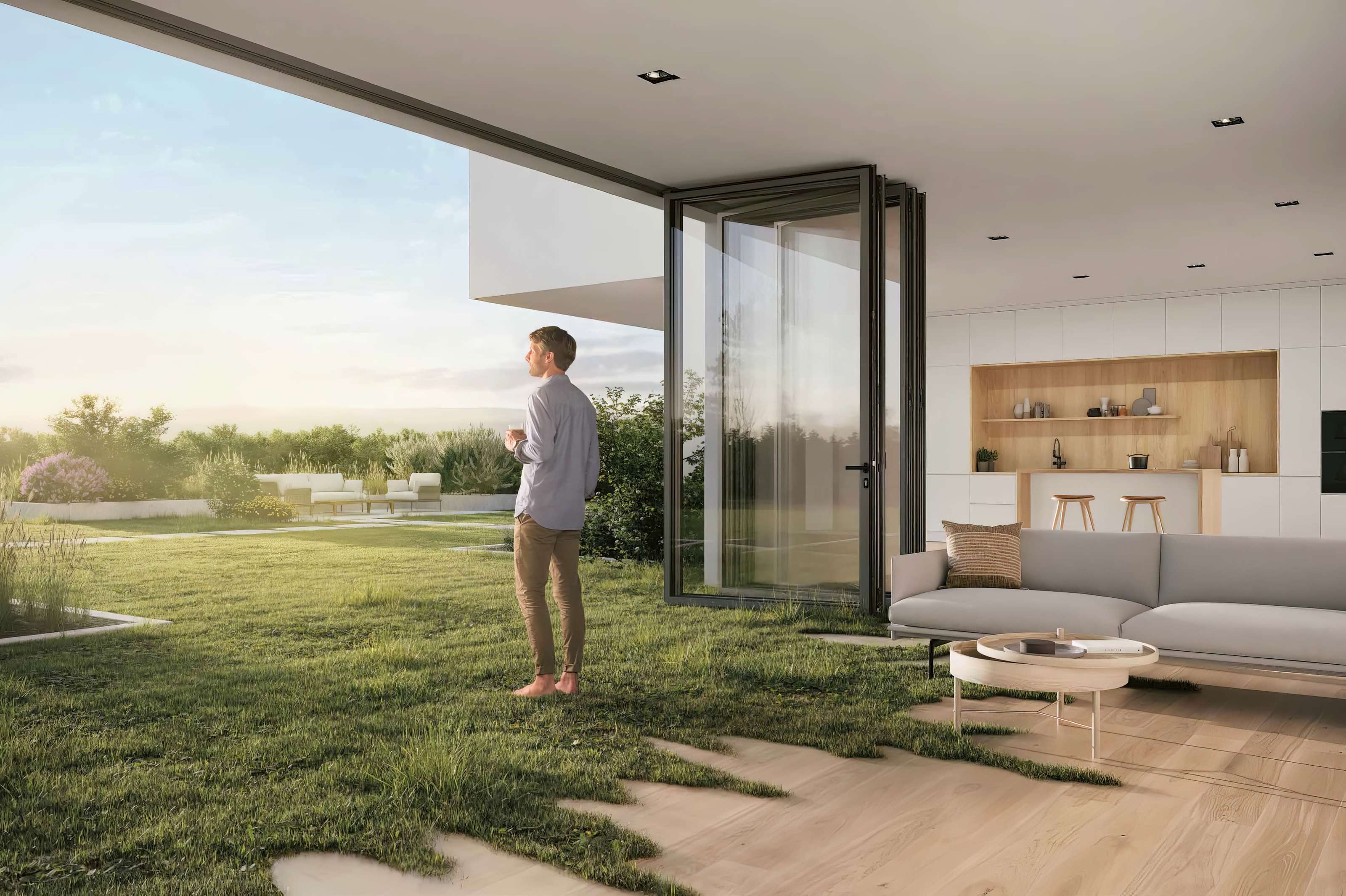 Person standing in a modern living room with open sliding glass doors, overlooking a grassy garden and enjoying a drink.
