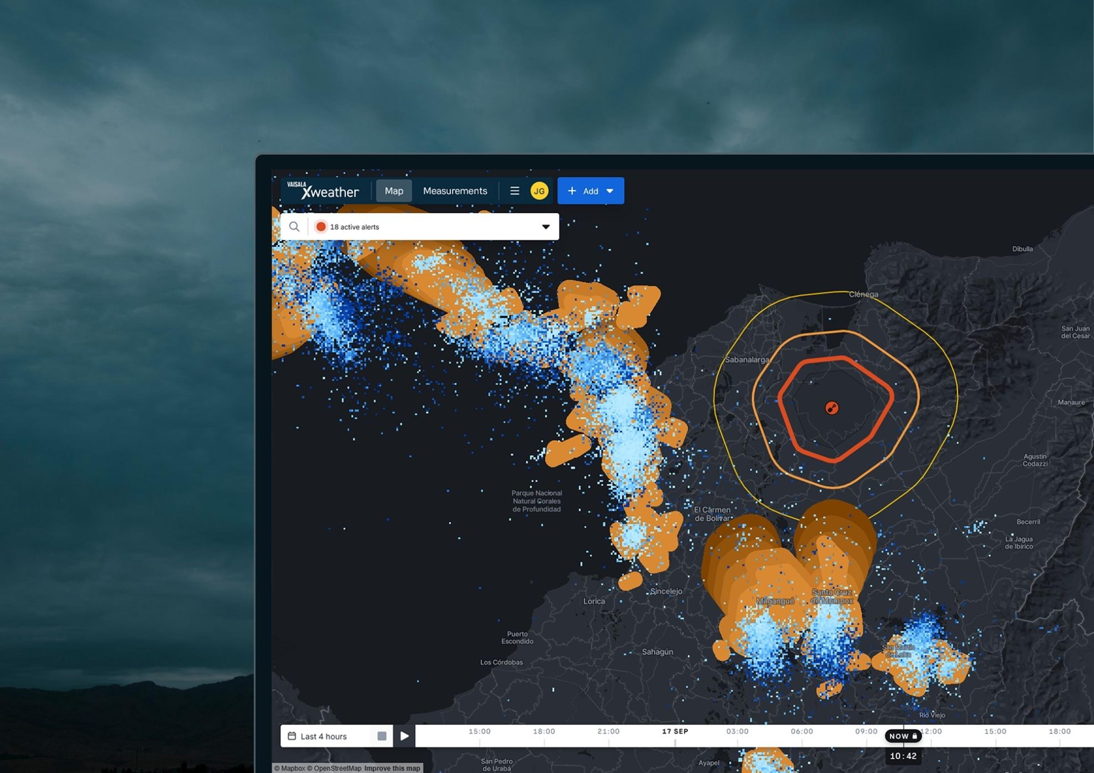 Xweather Protect software with weather layers and alert rings displayed on a monitor