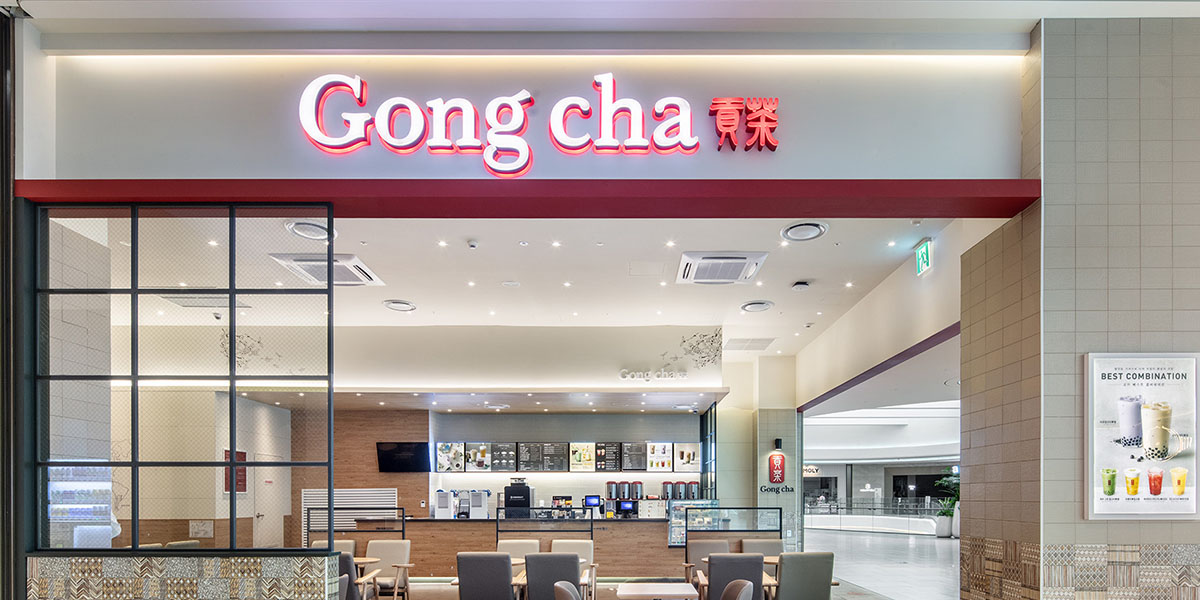 Gong Cha storefront in a mall with illuminated sign, modern service counter and seating for bubble tea.