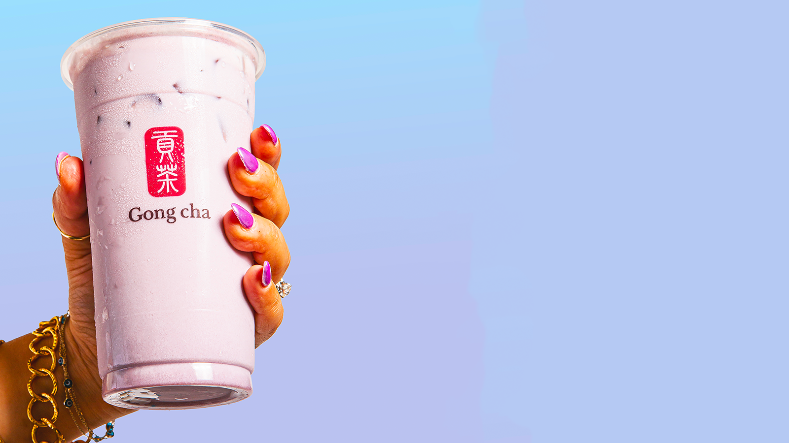 Purple taro milk tea in a Gong cha cup with black tapioca pearls and a branded straw