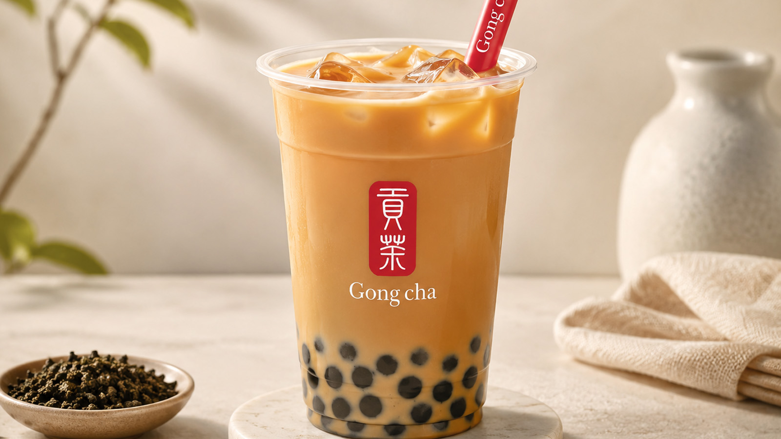 Roasted amber oolong milk tea in a Gong cha cup with black tapioca pearls and a branded straw