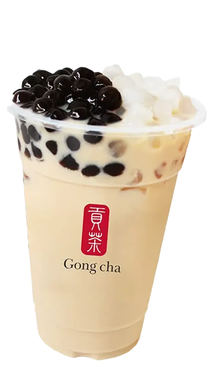 A plastic cup of Gong Cha bubble tea topped with black tapioca pearls and white coconut jelly.