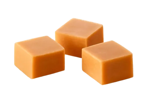 Three caramel squares with a smooth, glossy texture on a white background.