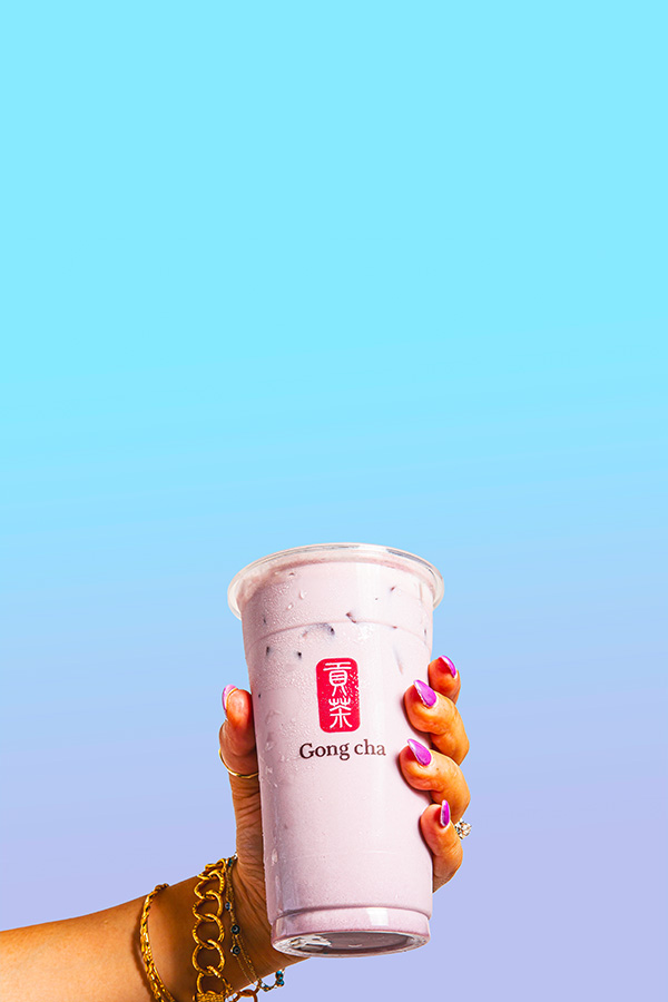 Purple taro milk tea in a Gong cha cup with black tapioca pearls and a branded straw