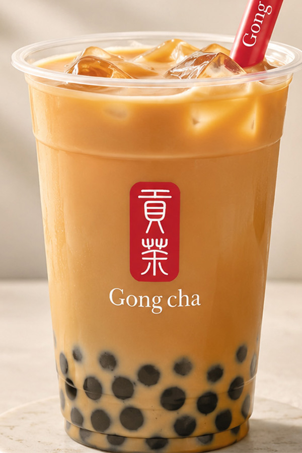 Roasted amber oolong milk tea in a Gong cha cup with black tapioca pearls and a branded straw