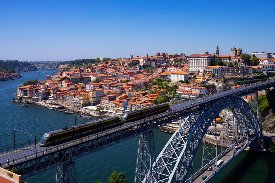 Train travelling over bridge in a European city