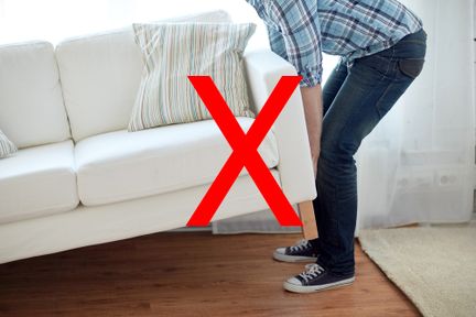 Photo of a person moving furniture, with a cross through it