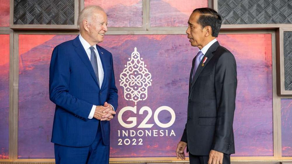 Biden and Widodo stand facing each other in front of G20 Indonesia 2022 logo
