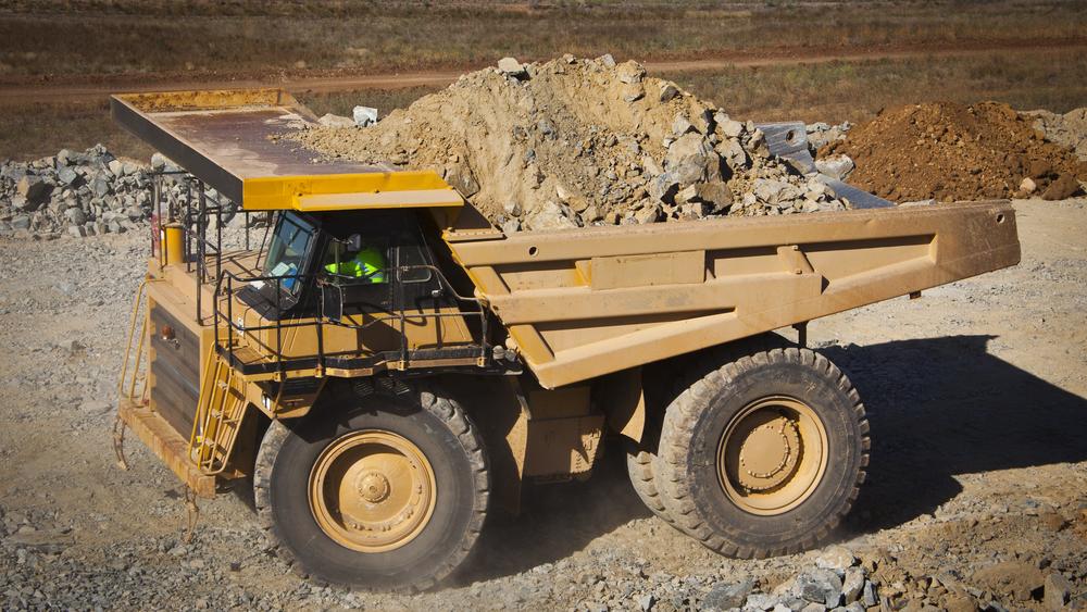 Large yellow truck used in modern lithium mine in Western Australia. A truck transports ore from the open cast mine.