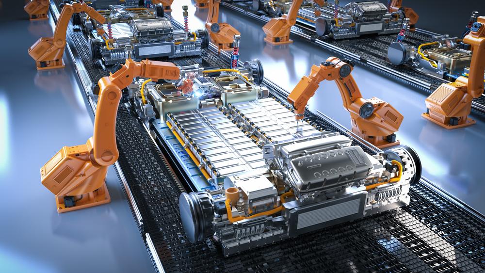 Robot arms assemble a battery pack on a construction line