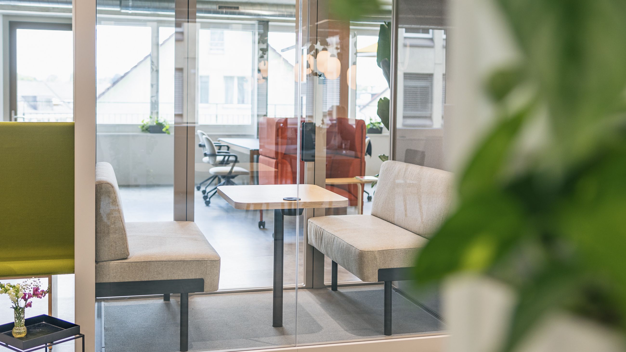 Besprechugngsbox mit zwei Sofas und einem Tisch.