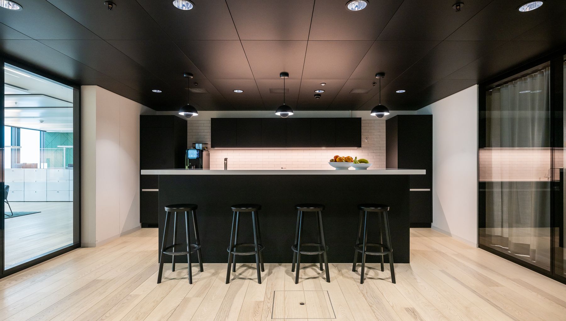 Elegante Büroküche mit schwarzer Küchenzeile, heller Arbeitsplatte.